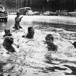 MAKE A STREET POOL: "1957. New York children splash about in a flooded street after the police opened the fire hydrants to beat the unbearable heat of summer."